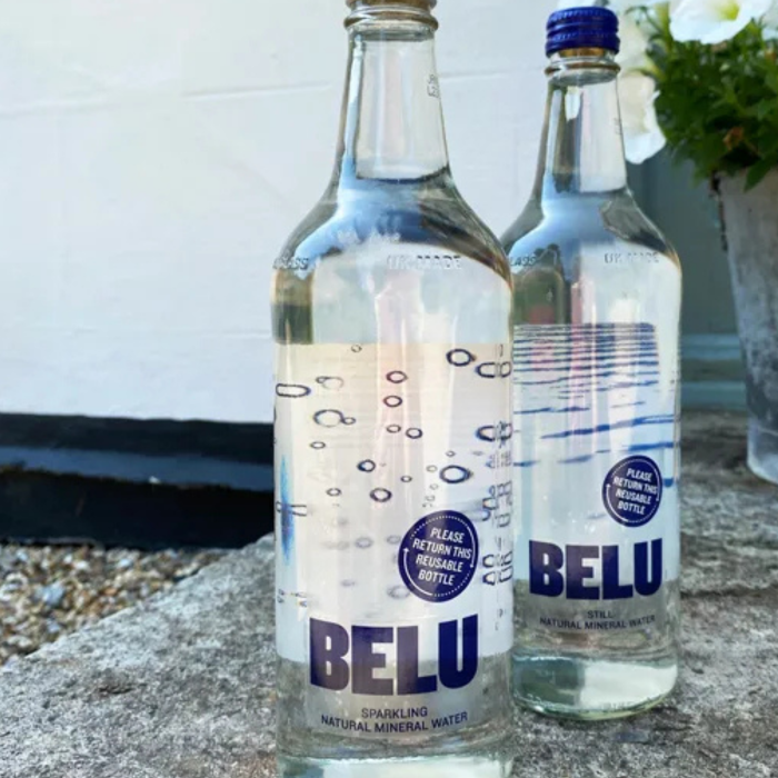 Two glass bottles of Belu water, one labeled 